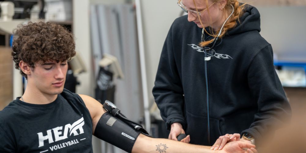 Undergraduate students test blood pressure in their classroom lab.