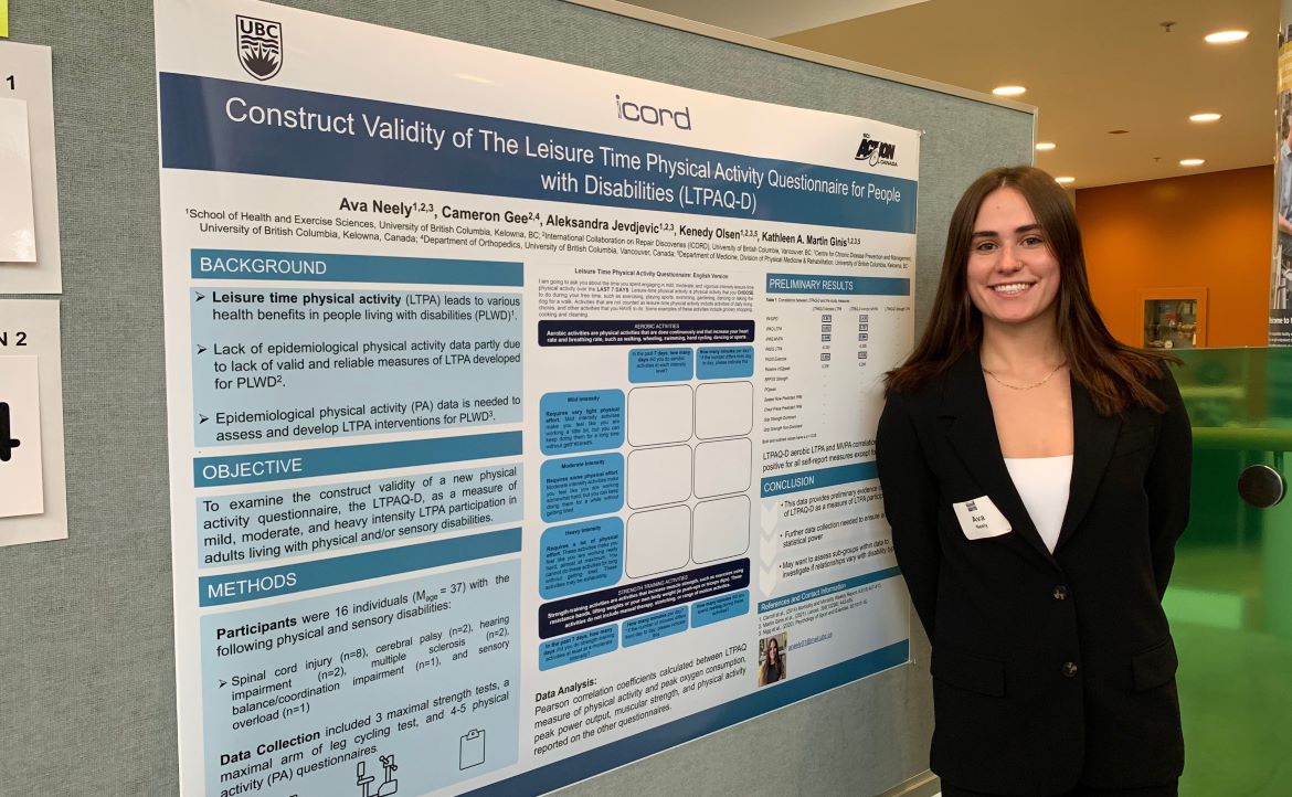 Ava Neely standing by her poster presentation of her Honours Thesis